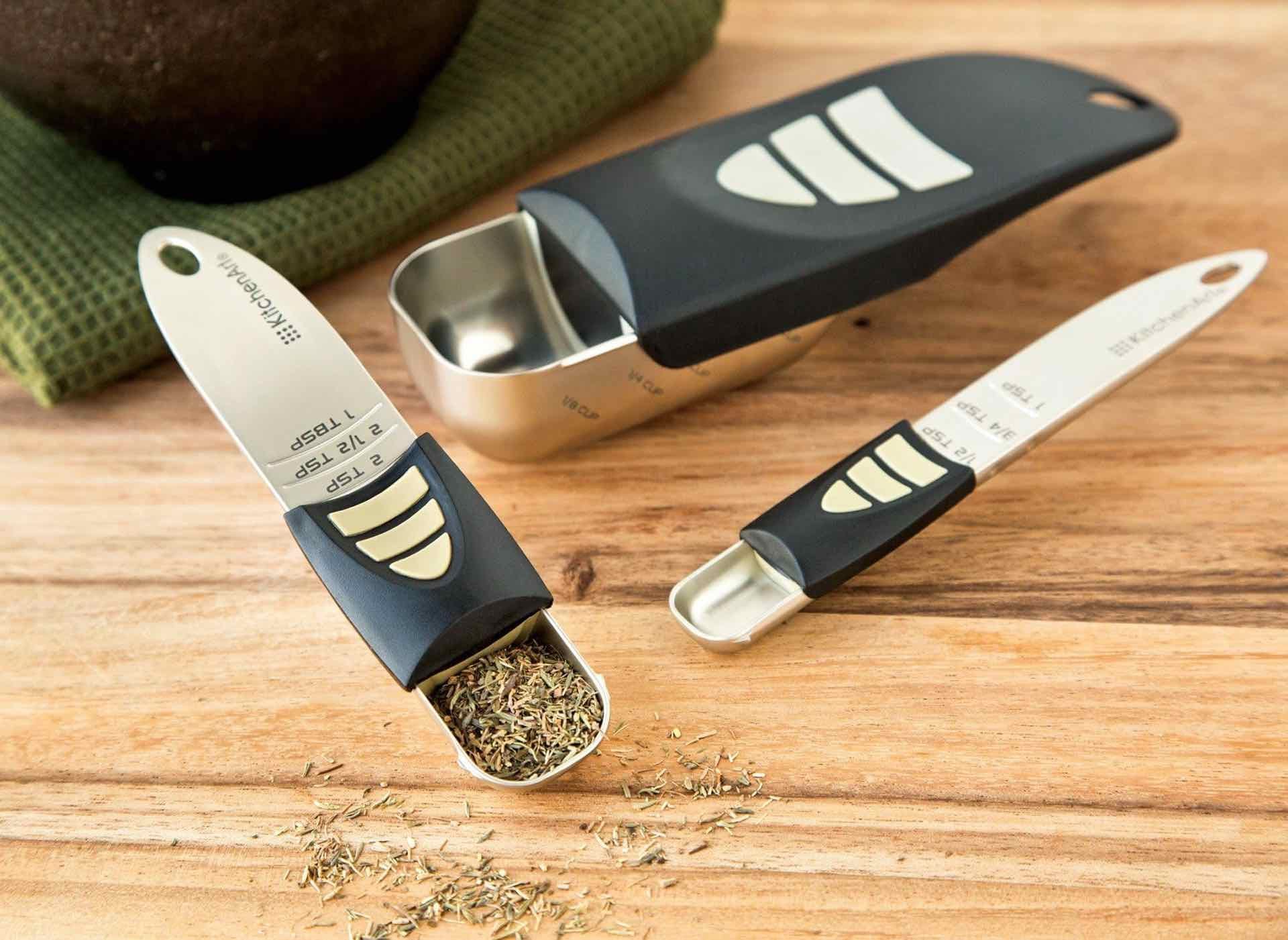 Set of adjustable measuring spoons and cups by KitchenAid, made of stainless steel and plastic. The sliding mechanism allows easy measurement adjustments for precise ingredient portioning. Ideal for dry and liquid ingredients.