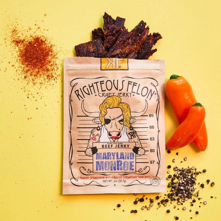 Righteous Felon Maryland Monroe Craft Jerky in signature packaging, with sweet peppers, crushed black pepper, and chili powder on a yellow background.